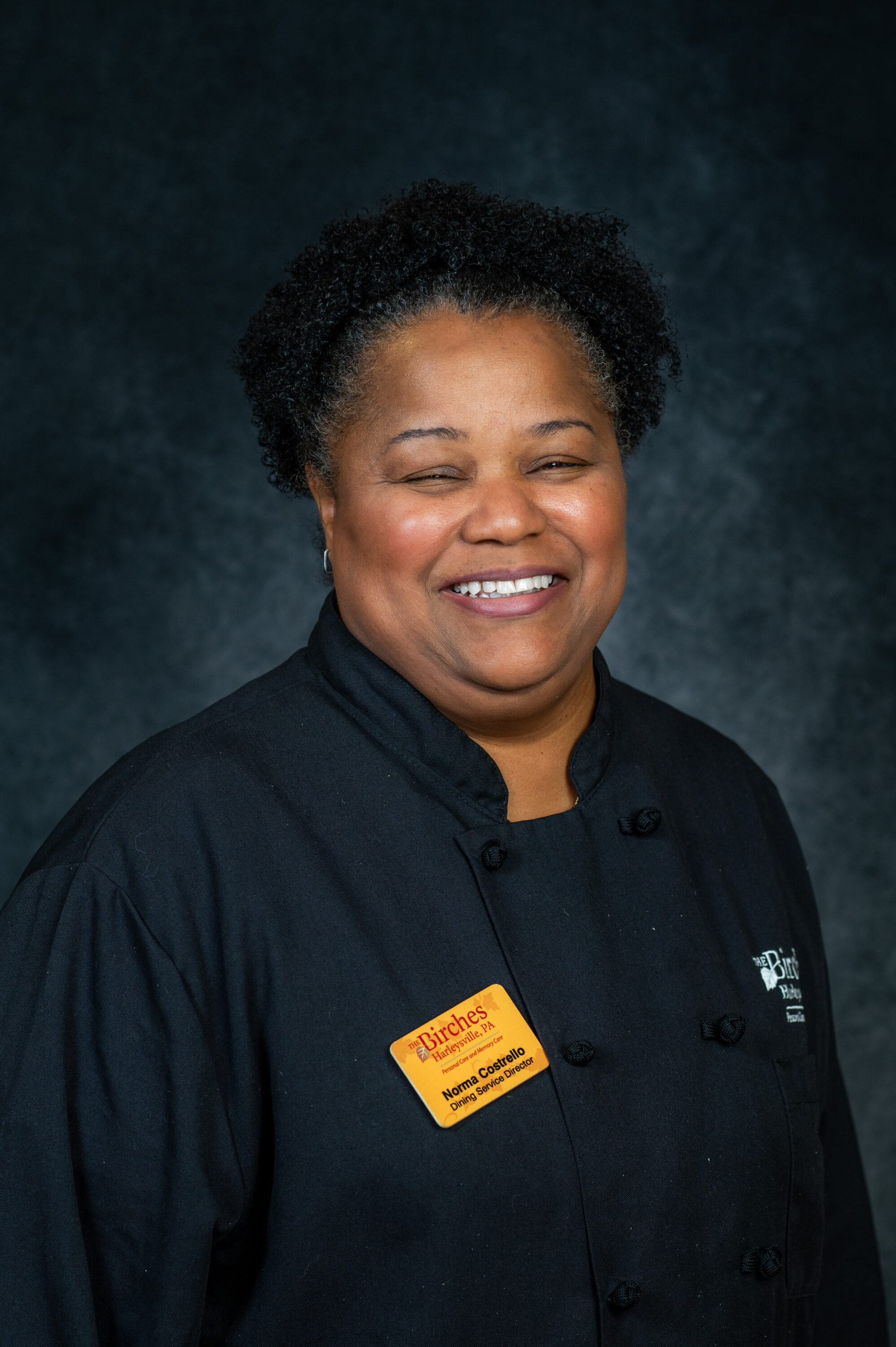 Smiling dining service director in chef coat portrait
